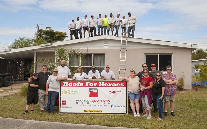 The Florida Southern Roofing team that participated in the 2019 Roofs for Heroes project and Mr Bostic and his family.
